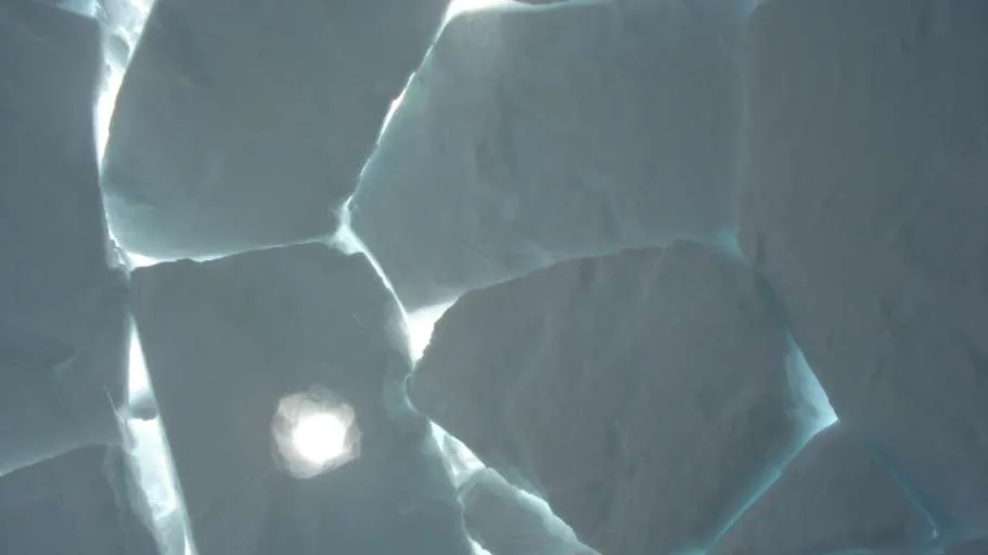 Close-up of igloo blocks with light streaming through the cracks.